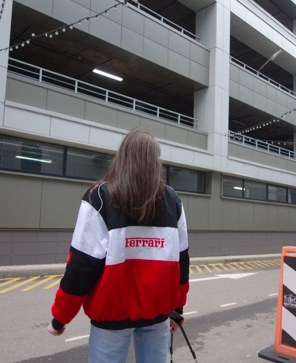 Back view showcasing Ferrari branding on white racing jacket